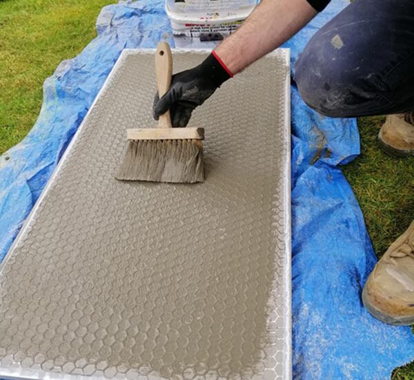 Applying primer to a paving slab