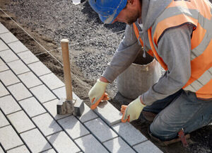 Contractor lays paving on mortar bed