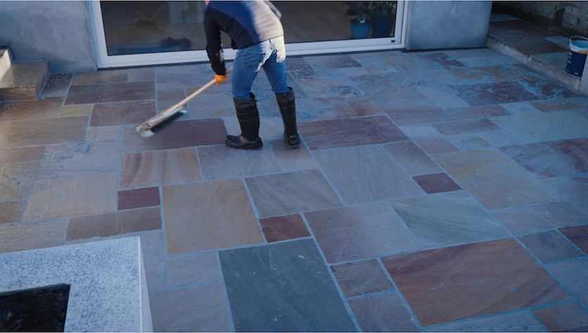 Paving contractor sweeps off excess grout
